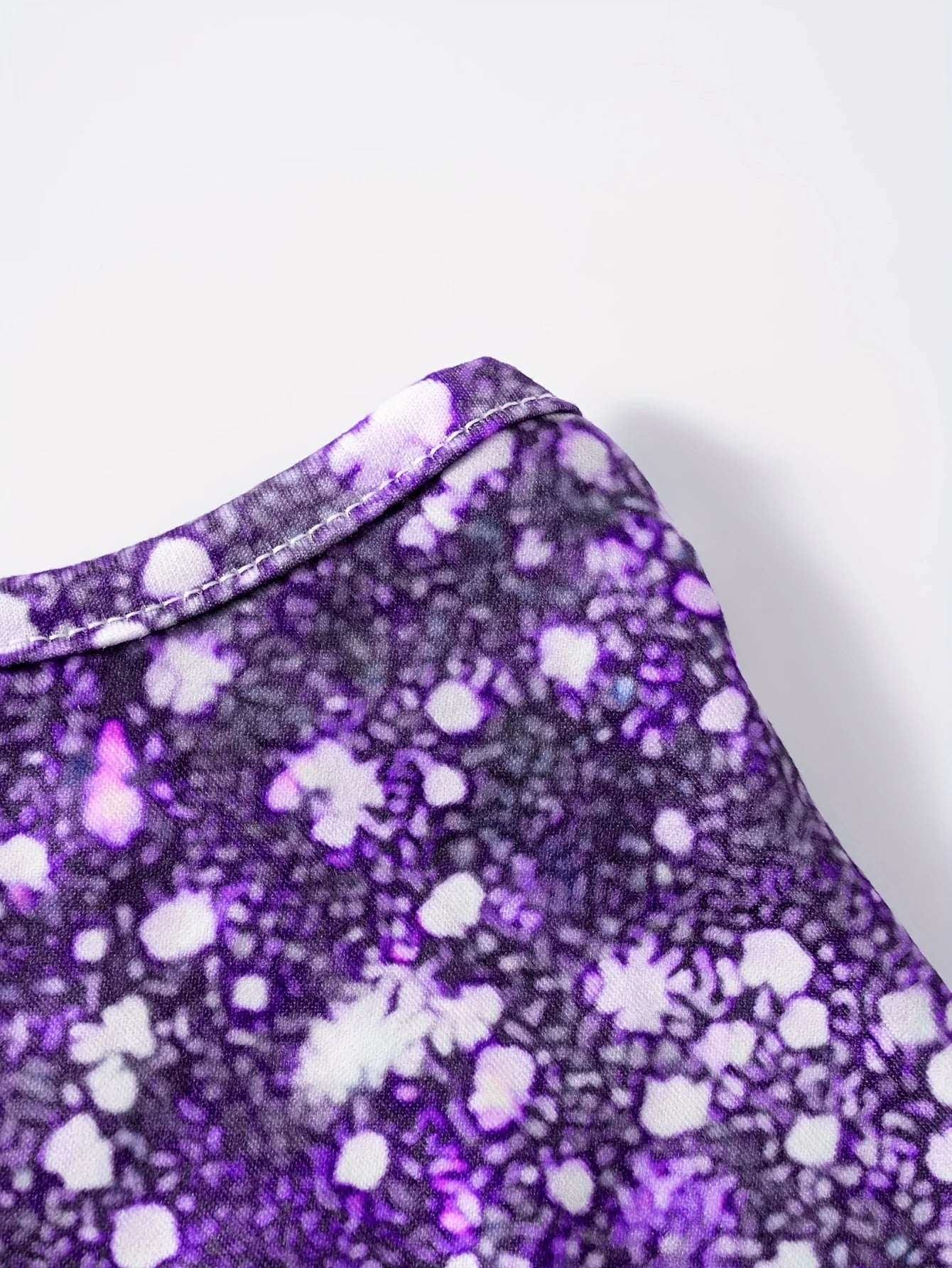 This round neck spaghetti strap maxi dress features a dazzling purple glitter, butterfly print on a sleek black base.